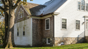 Connecticut home exterior showing uneven paint aging, shaded siding exposure and weathered cedar shingles